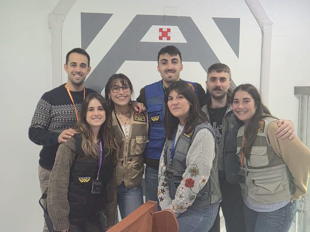 Grupo de siete personas sonriendo en un fondo con un diseño moderno.